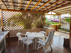 萨利纳斯Villa cerca al malecón de Salinas para 10 personas的庭院里设有白色桌椅。