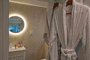 a robe hanging in a bathroom with a sink at Cornish Dreams in Camborne