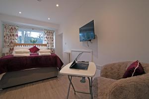 a bedroom with a bed and a laptop on a table at Cornish Dreams in Camborne