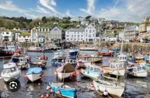 a group of boats docked in the water in a harbor at Cornish Dreams in Camborne