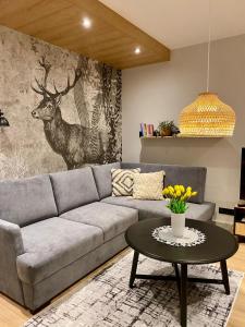 a living room with a couch and a table at REST4U APARTAMENTY z SAUNAMI in Szczyrk