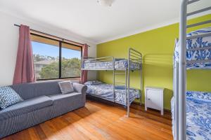 ein Wohnzimmer mit einem Sofa und Etagenbetten in der Unterkunft The Beachfront in Lake Cathie