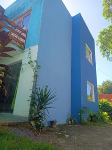 a blue building with plants in front of it at Apartamento na Concha in Itacaré