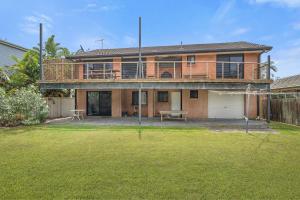 ein großes Haus mit Terrasse und Garten in der Unterkunft The Beachfront in Lake Cathie