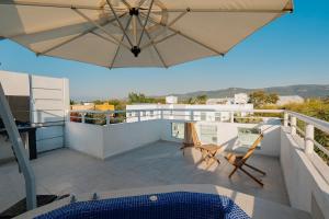 a patio with an umbrella and chairs on a balcony at Family House with Pool and Jacuzzi in Morelos in Chiconcuac