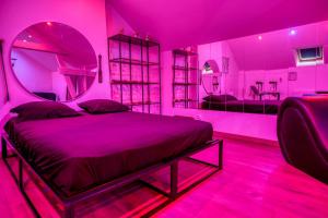 a bedroom with a bed in a pink room at La Villa Monroe - Un écrin de volupté épicée in Le Vézier +20 photos