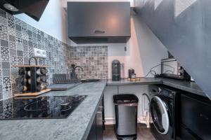 a kitchen with a washer and dryer on a counter at La Villa Monroe - Un écrin de volupté épicée in Le Vézier