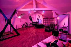 a room with purple lighting and a room with chairs and tables at La Villa Monroe - Un écrin de volupté épicée in Le Vézier