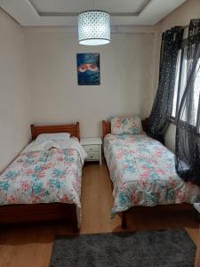 una camera da letto con due letti e un quadro sul muro di Mohemmadia a Mohammedia