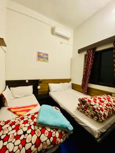 a room with two beds and a tv in it at Hotel MAQ Lumbini in Lumbini +24 photos