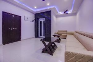 OYO Flagship Grand Mythri في Maula Ali: غرفة معيشة بها أريكة وطاولة +26 صورة