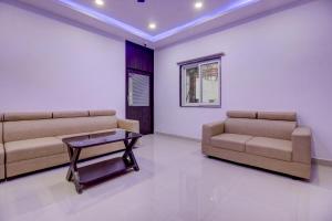 OYO Flagship Grand Mythri في Maula Ali: غرفة معيشة مع أريكتين وطاولة قهوة
