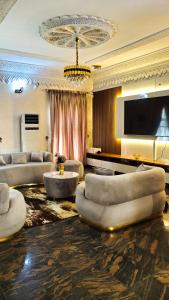 un ampio soggiorno con divani e televisione di Sunabi Hotels and Apartments ad Abuja