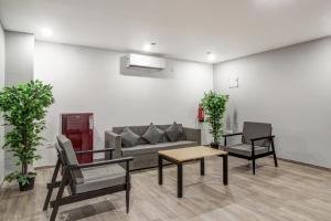 a room with a couch and two chairs and a table at Super Townhouse RCC Majestic 397 LB Nagar in Hyderabad +60 photos