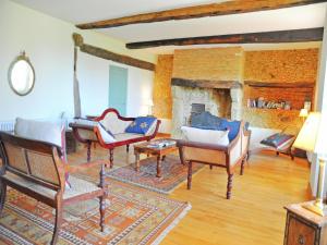a living room with chairs and a fireplace at Beautiful farmhouse with private pool in Le Houga