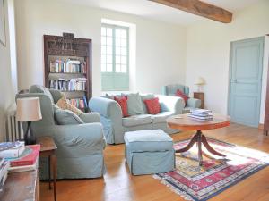 a living room with a couch and a table at Beautiful farmhouse with private pool in Le Houga