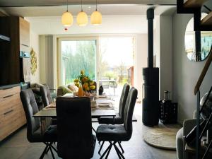 MontenakenPeaceful holiday home near Hannut的餐厅里有一张桌子和几把椅子