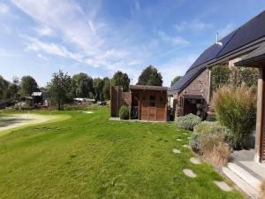 MontenakenPeaceful holiday home near Hannut的一座房子,房子旁边是一座庭院