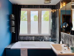 een badkamer met een bad, een wastafel en een raam bij Apartament Kochanowskiego Łódź in Łódź +46 foto's