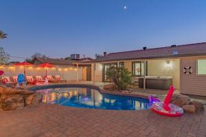 a swimming pool with chairs and a house at Ella Oasis Heated Pool Hot Tub Near Old Town in Scottsdale