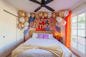a bedroom with a bed with balloons and a happy birthday sign at Ella Oasis Heated Pool Hot Tub Near Old Town in Scottsdale