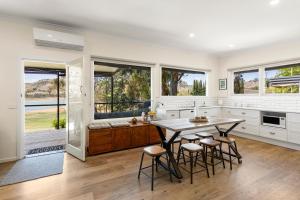 eine Küche mit Tisch, Stühlen und Fenstern in der Unterkunft Gafia in Bonnie Doon