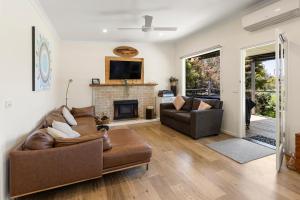 ein Wohnzimmer mit zwei Sofas und einem Kamin in der Unterkunft Gafia in Bonnie Doon