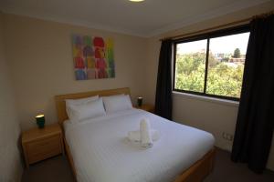 una camera da letto con un letto con un oggetto bianco sopra di Central Park 18 1 Snowy River Ave a Jindabyne
