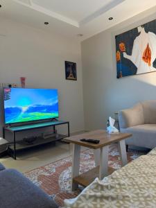 een woonkamer met een grote flatscreen-tv bij شقة الفخامة in Al Madinah