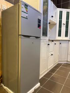 a stainless steel refrigerator in a kitchen with white cabinets at شقة الفخامة in Medina +5 photos