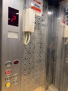 een telefoon hangt aan de muur in een kamer bij شقة الفخامة in Al Madinah