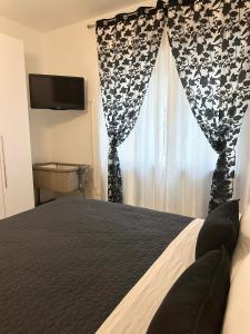 Lora's House 5Terre في لا سبيتسيا: غرفة نوم بسرير ونافذة بها تلفزيون