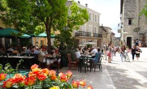 een groep mensen die aan tafel zitten in een stadsstraat bij L'Orée du Loup in La Colle-sur-Loup
