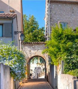 een steegje met een boog in een stenen gebouw bij L'Orée du Loup in La Colle-sur-Loup