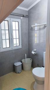 um banheiro com vaso sanitário e janela em Banda Além Apartment by Mth em Tábua