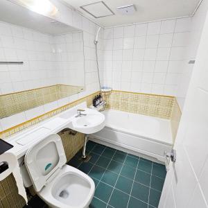 Un baño con inodoro, lavabo y bañera. en Ocean House PH, en Pohang