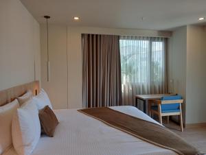 Un dormitorio con una cama y un escritorio y una ventana. en Hotel Rulay Medellin, en Medellín