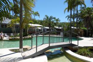 uma ponte sobre uma piscina num resort com palmeiras em Koala Shores Holiday Park em Lemon Tree Passage mais 32 fotografias