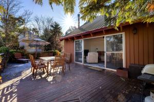ジンダバインにあるMogul Lakeside - East Jindabyneのデッキにテーブルと椅子が置かれたパティオ