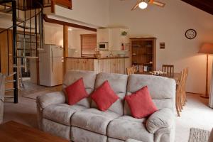 ジンダバインにあるMogul Lakeside - East Jindabyneのリビングルーム(赤い枕2つ付きのソファ付)