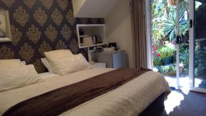 Un dormitorio con una cama con una ventana grande. en Linley House, en Sídney