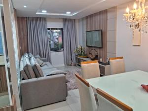 a living room with a couch and a table at Casa com piscina, suite com hidro em Blumenau in Blumenau