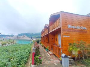 a wooden building with plants on the side of it at Dieng Indah Villa & Cabin by Hello Room in Dieng