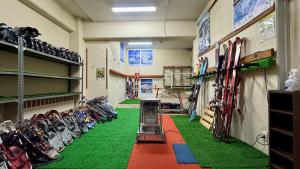 um quarto com piso verde em um quarto com esquis em 志賀 石の湯ホテル em Yamanouchi