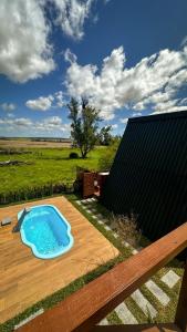 a small swimming pool on a wooden deck at Cabanas Farol in Pântano Grande