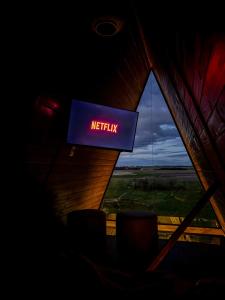 a sign that says netflix in a room with a window at Cabanas Farol in Pântano Grande