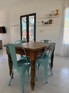 un tavolo in legno con due sedie verdi intorno di Casona alegre con pileta y patio a San Pedro