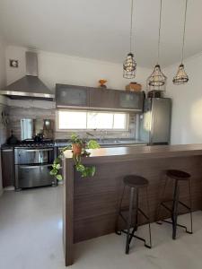 una cucina con bancone e due sgabelli di Casona alegre con pileta y patio a San Pedro