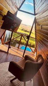 una sedia davanti a una grande finestra con una tv di Cabanas Farol a Pântano Grande