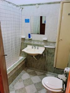 een badkamer met een wastafel, een toilet en een douche bij Hotel Ritz in Villa Carlos Paz